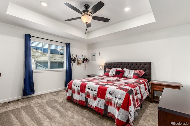 carpeted bedroom with recessed lighting, a ceiling fan, a raised ceiling, and baseboards