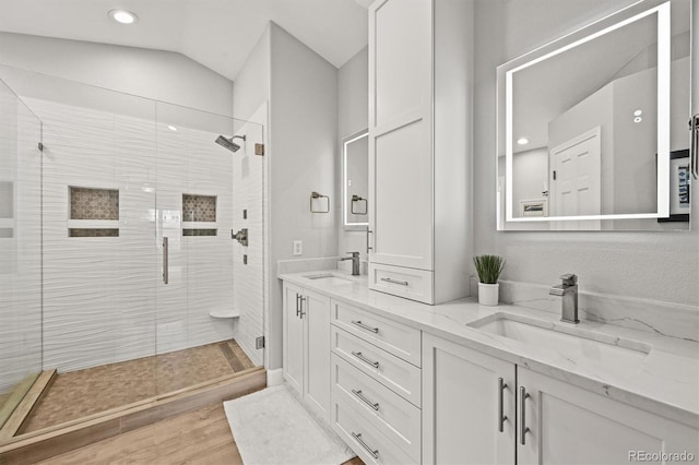 6105 W Long Dr, Littleton, CO 80123 - full bathroom featuring double vanity, a shower stall, lofted ceiling, recessed lighting, and wood finished floors
