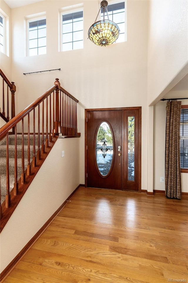 foyer with plenty of natural light, wood finished floors, and baseboards