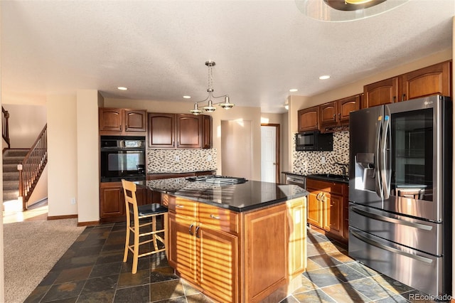 kitchen featuring a center island, stone tile floors, tasteful backsplash, dark countertops, and black appliances