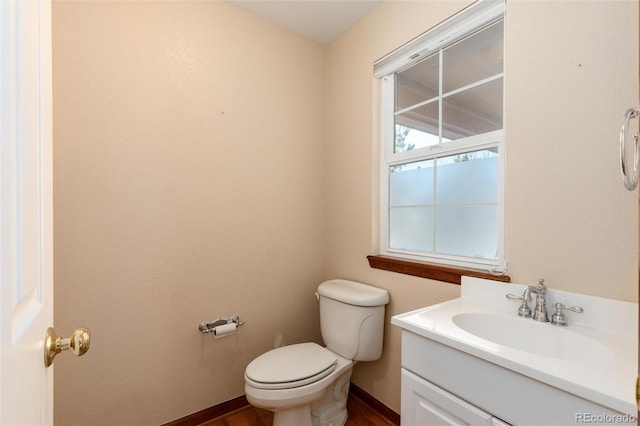 bathroom with baseboards, vanity, and toilet