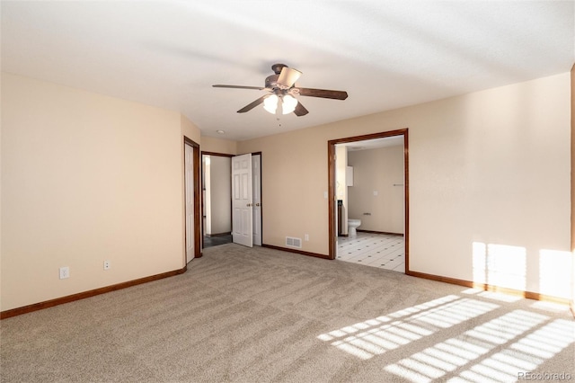 unfurnished bedroom featuring light colored carpet, visible vents, a ceiling fan, connected bathroom, and baseboards