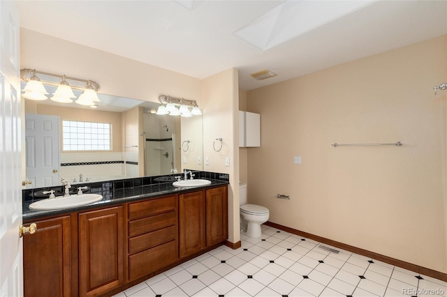 full bathroom featuring double vanity, a stall shower, a skylight, and a sink