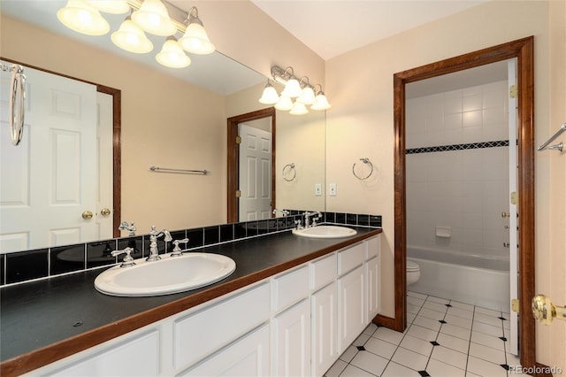 bathroom featuring double vanity, toilet, a sink, and tile patterned floors