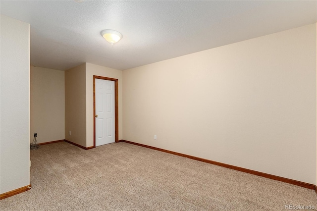 empty room featuring light carpet and baseboards