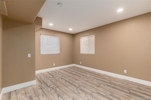 unfurnished room with light wood-style floors, baseboards, and recessed lighting