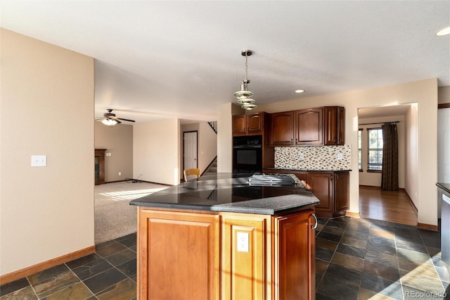 kitchen featuring a center island, dark countertops, stone tile flooring, decorative backsplash, and black oven