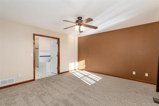 empty room with carpet, visible vents, ceiling fan, and baseboards