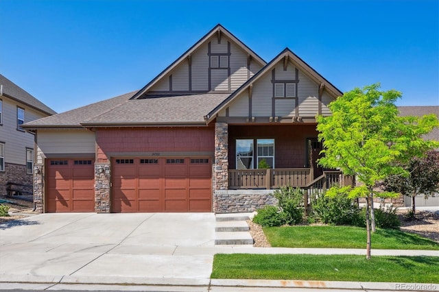 24322 E Mineral Dr, Aurora, CO 80016 - view of front of property featuring a porch, a garage, concrete driveway, and stone siding