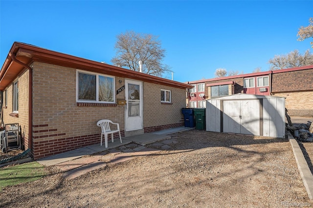 rear view of property with a storage shed