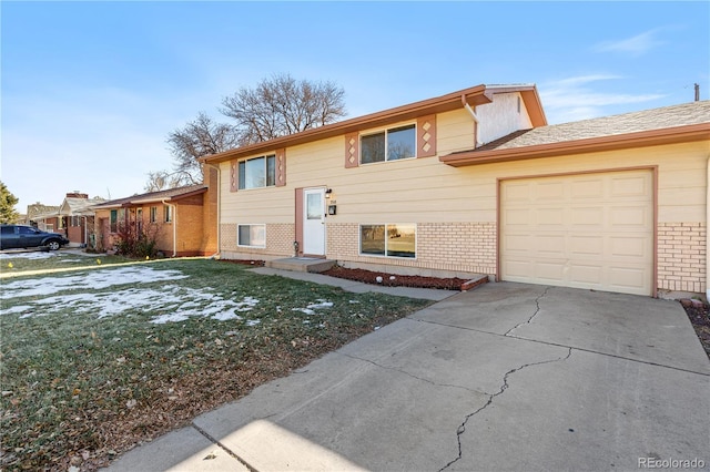 raised ranch with a front lawn and a garage