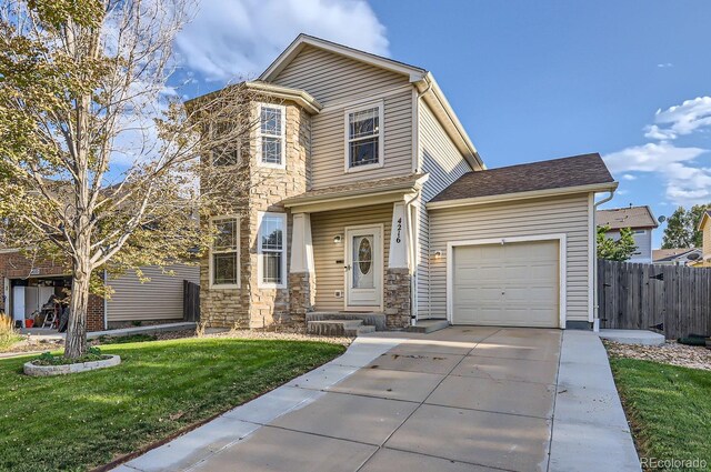 traditional home with an attached garage, fence, driveway, stone siding, and a front lawn