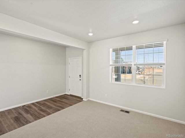 unfurnished room with recessed lighting, baseboards, visible vents, and dark colored carpet