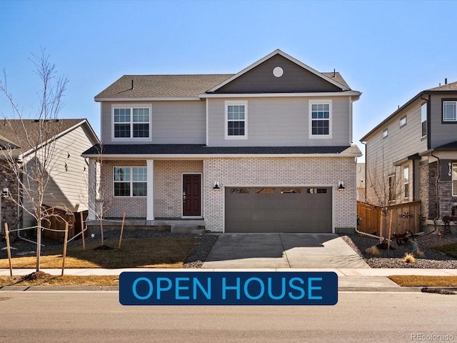 traditional-style house with brick siding, an attached garage, concrete driveway, and fence