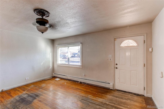 foyer with baseboard heating, wood-type flooring, and a textured ceiling