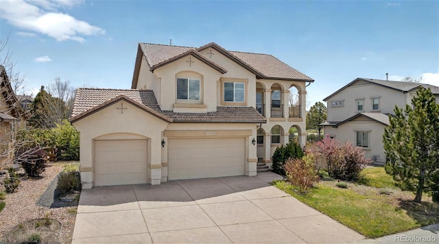 16043 Bridle Ridge Dr, Monument, CO 80132 - mediterranean / spanish home featuring stucco siding, a tiled roof, concrete driveway, and an attached garage