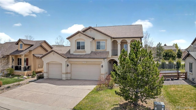 16043 Bridle Ridge Dr, Monument, CO 80132 - mediterranean / spanish home with stucco siding, driveway, fence, a tile roof, and an attached garage