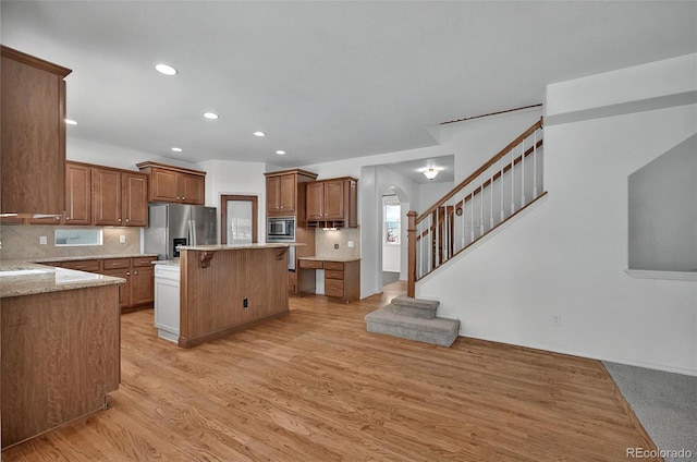 16043 Bridle Ridge Dr, Monument, CO 80132 - kitchen featuring appliances with stainless steel finishes, a kitchen bar, tasteful backsplash, a kitchen island, and recessed lighting