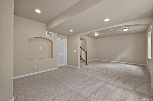 16043 Bridle Ridge Dr, Monument, CO 80132 - empty room featuring light colored carpet, stairs, recessed lighting, baseboards, and arched walkways
