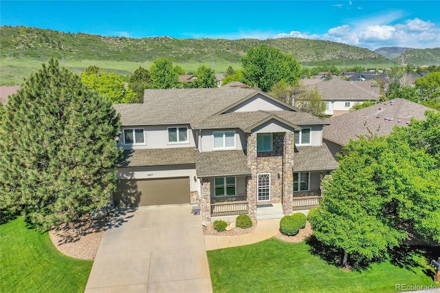 8427 S Parfet Ct, Littleton, CO 80127 - view of front facade with stone siding, concrete driveway, stucco siding, a garage, and a shingled roof