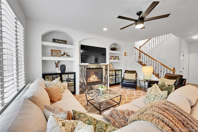 8427 S Parfet Ct, Littleton, CO 80127 - living area featuring a premium fireplace, ceiling fan, built in shelves, stairway, and recessed lighting