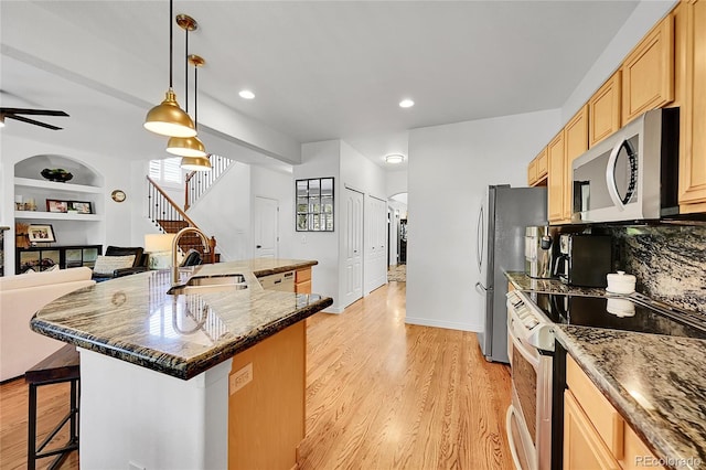 8427 S Parfet Ct, Littleton, CO 80127 - kitchen featuring appliances with stainless steel finishes, a sink, a kitchen breakfast bar, ceiling fan, and light brown cabinetry