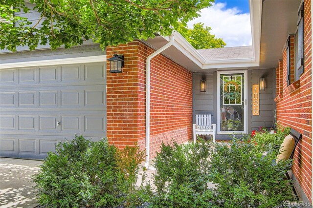 7036 Robb St, Arvada, CO 80004 - entrance to property featuring brick siding and a garage