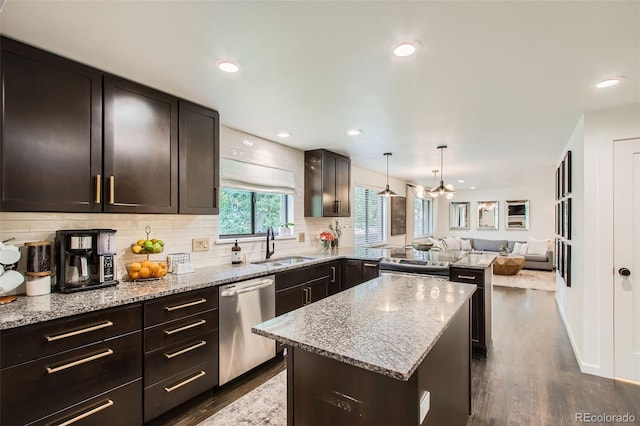 7036 Robb St, Arvada, CO 80004 - kitchen featuring stainless steel appliances, open floor plan, dark wood-type flooring, backsplash, and light stone counters