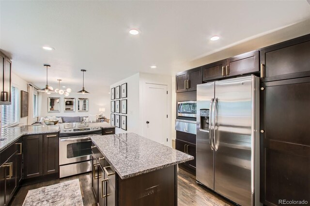 7036 Robb St, Arvada, CO 80004 - kitchen with appliances with stainless steel finishes, a warming drawer, dark wood-style floors, light stone counters, and open floor plan