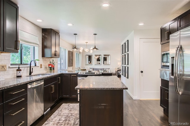 7036 Robb St, Arvada, CO 80004 - kitchen with appliances with stainless steel finishes, dark wood-type flooring, light stone countertops, a warming drawer, and backsplash