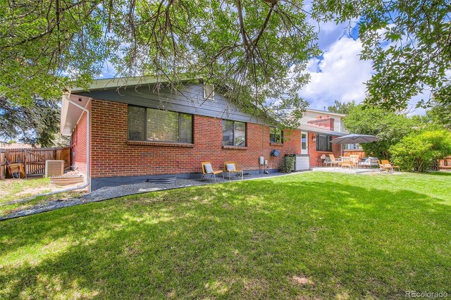 7036 Robb St, Arvada, CO 80004 - back of house with brick siding and a patio