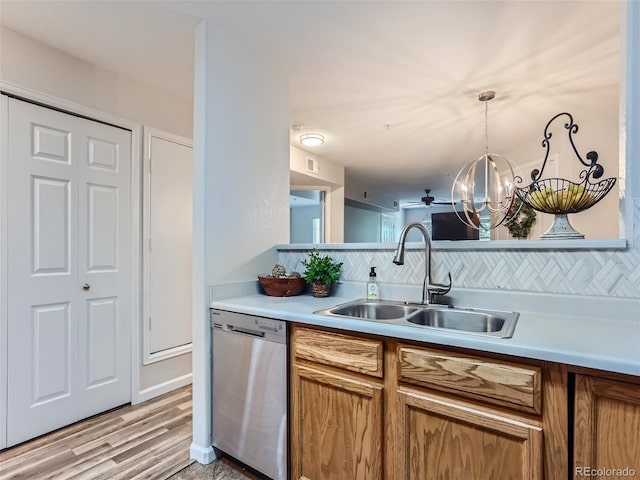 kitchen featuring tasteful backsplash, light hardwood / wood-style flooring, stainless steel dishwasher, and a notable chandelier