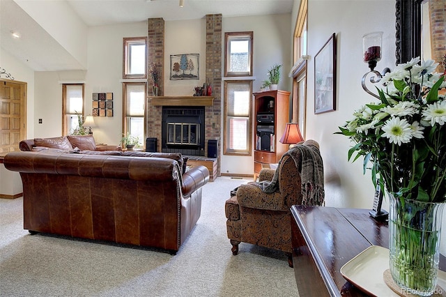 living area featuring baseboards, light colored carpet, a fireplace, and a high ceiling