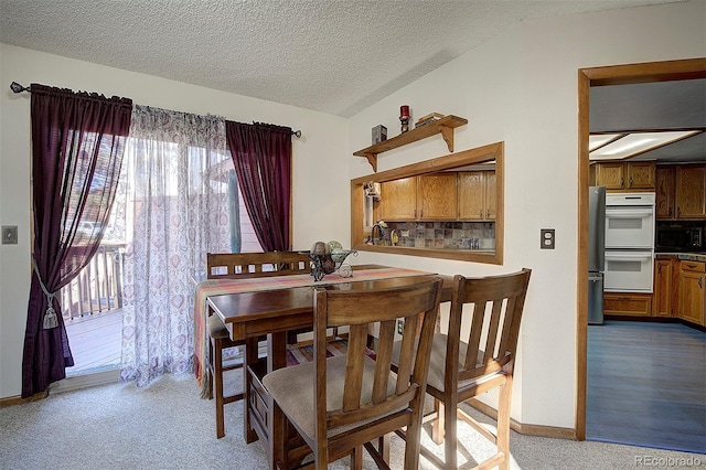 dining area with baseboards, a textured ceiling, and carpet flooring