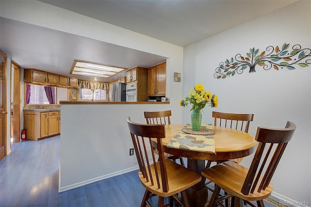 dining space with wood finished floors and baseboards