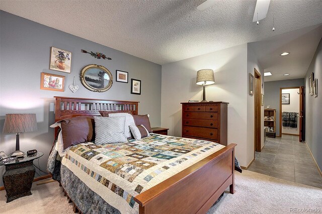 bedroom featuring light tile patterned floors, recessed lighting, light colored carpet, a textured ceiling, and baseboards