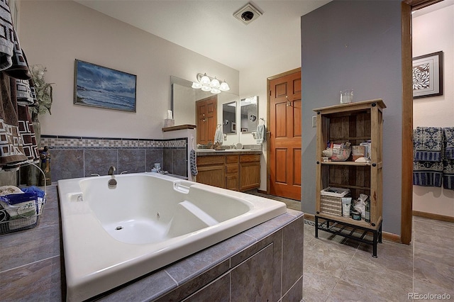 full bath featuring visible vents, a jetted tub, vanity, and tile patterned floors