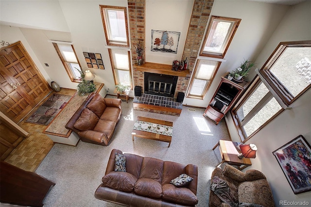 living area featuring a brick fireplace and a towering ceiling