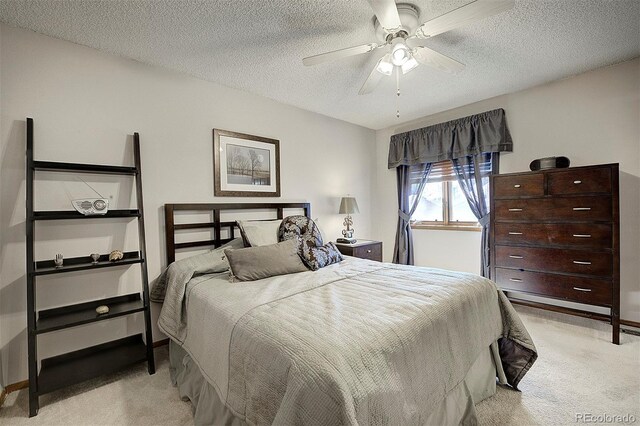 bedroom with light carpet, a ceiling fan, baseboards, and a textured ceiling