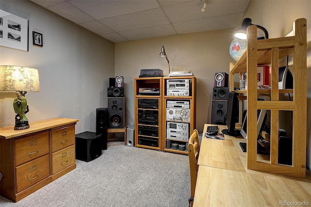 carpeted home office with a paneled ceiling