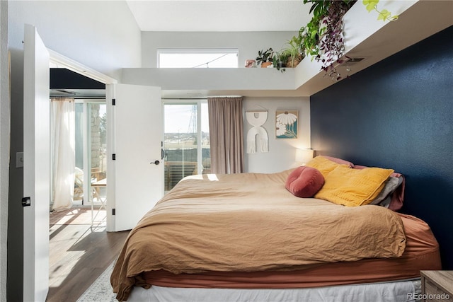 bedroom with access to exterior, visible vents, and wood finished floors