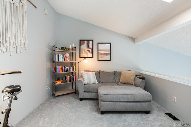 sitting room with carpet, visible vents, and vaulted ceiling with beams