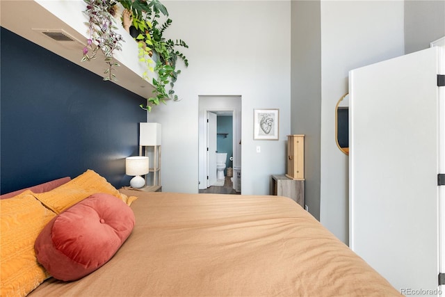 bedroom with a high ceiling and visible vents