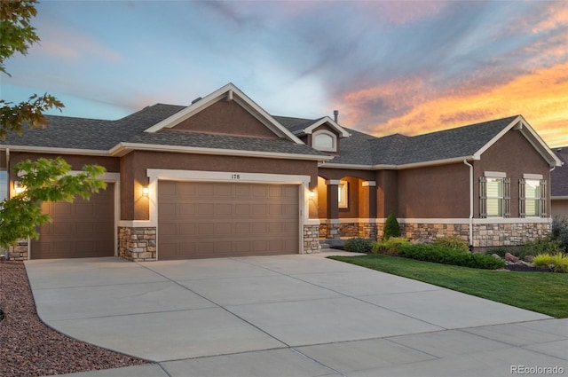 178 Coyote Willow, Colorado Springs, CO 80921 - view of front of home with stone siding, a garage, stucco siding, driveway, and roof with shingles