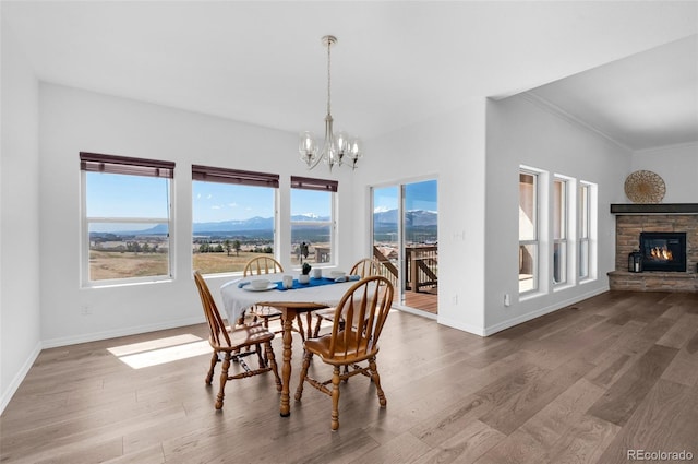 178 Coyote Willow, Colorado Springs, CO 80921 - dining space featuring a chandelier, baseboards, wood finished floors, crown molding, and a stone fireplace