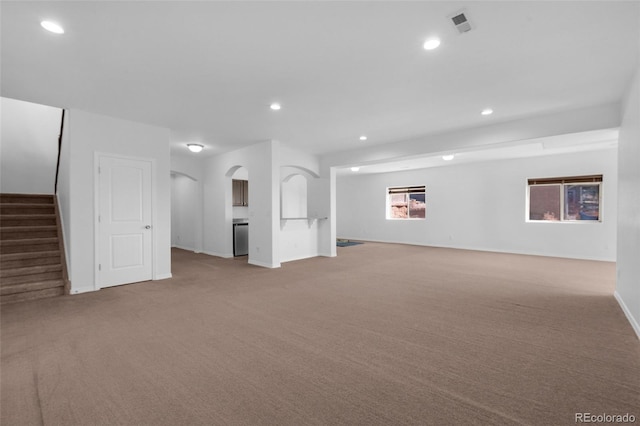 178 Coyote Willow, Colorado Springs, CO 80921 - unfurnished living room featuring carpet, recessed lighting, baseboards, arched walkways, and stairs