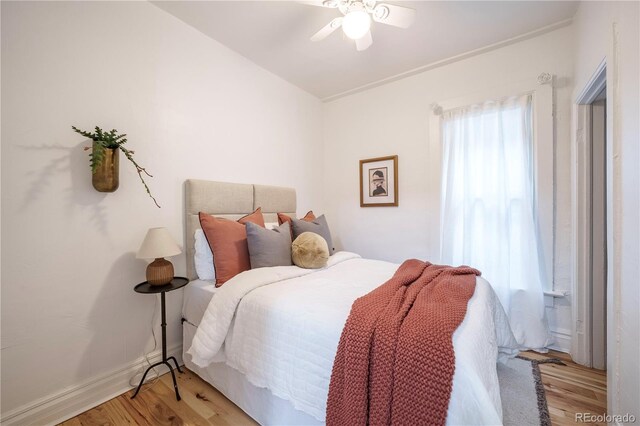 bedroom featuring light wood-style floors, ceiling fan, and baseboards