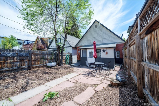 rear view of property with a patio area and a fenced backyard