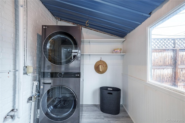 washroom featuring stacked washer and clothes dryer and wood finished floors