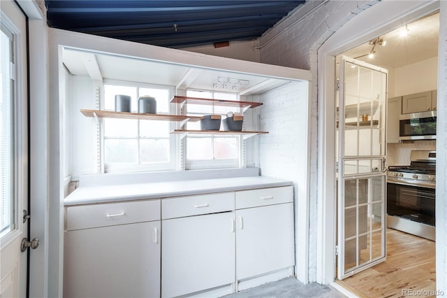 bar area featuring stainless steel appliances and light wood-type flooring